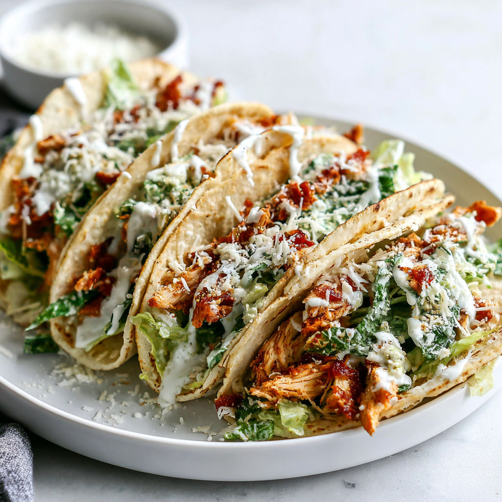 A plate of chicken tacos with lettuce and cheese.