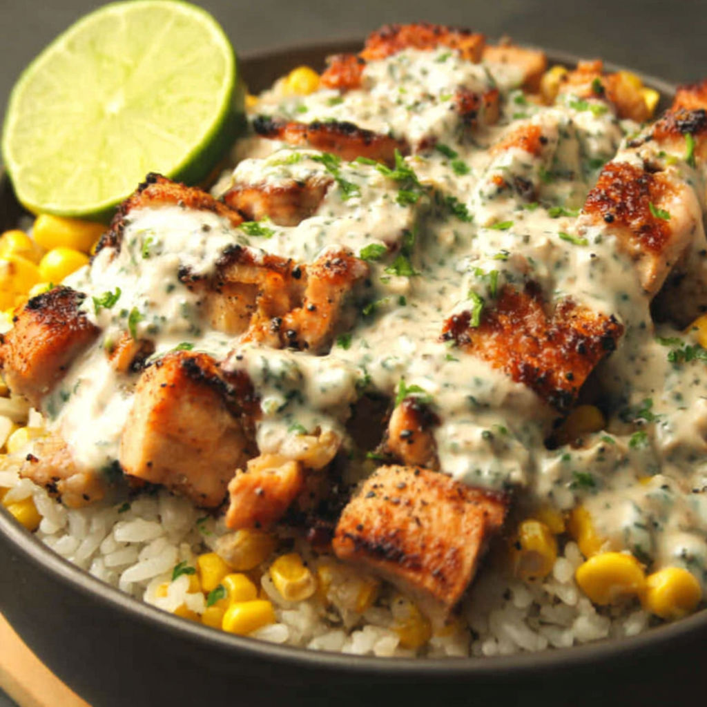 A bowl of rice with meat and sauce.