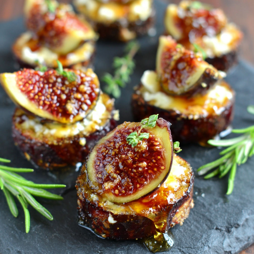 A plate of food with a fig on top.