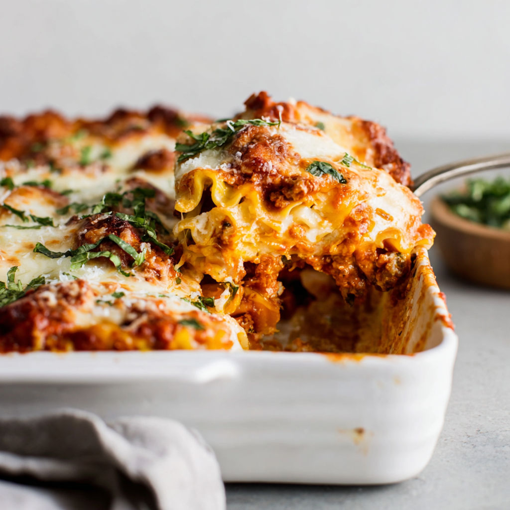 A dish of lasagna with a spoon in it.