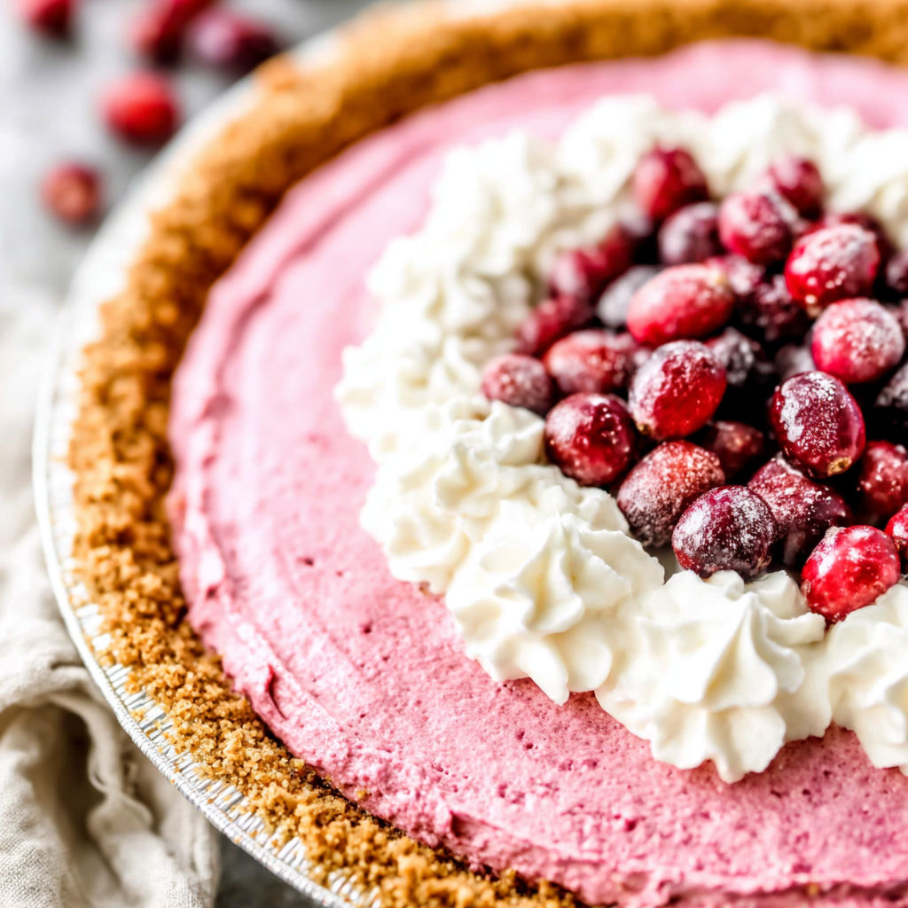 A slice of pie with white whipped cream and red berries.