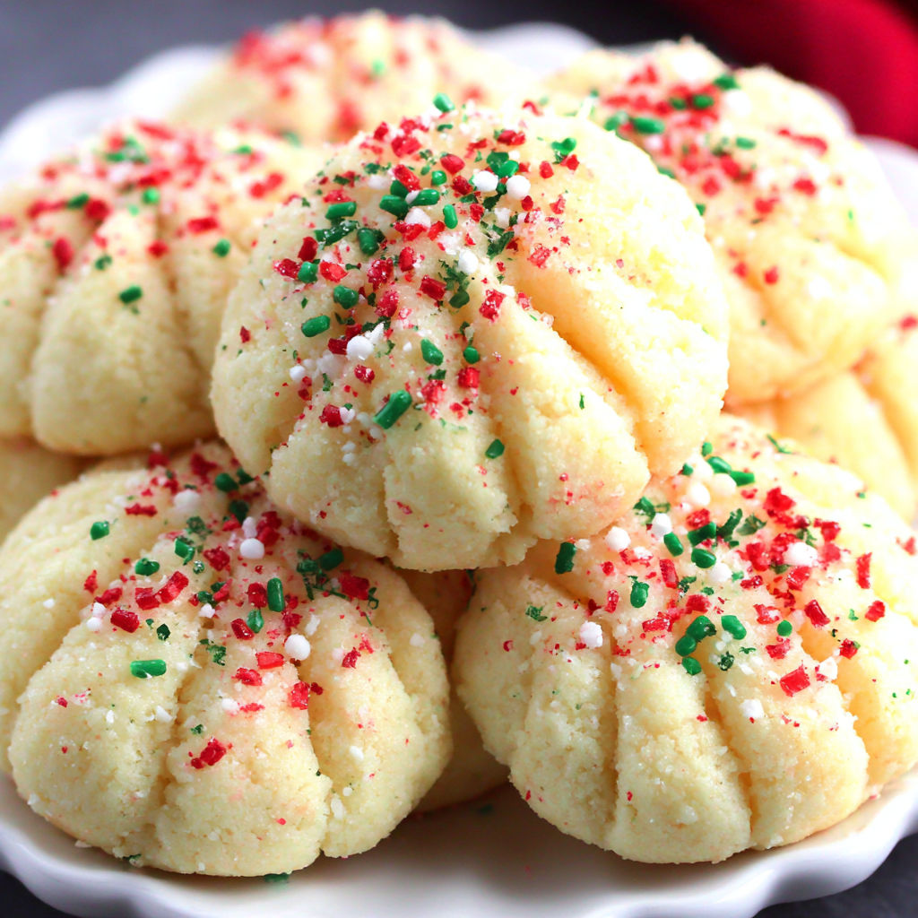 A plate of cookies with green and red sprinkles.