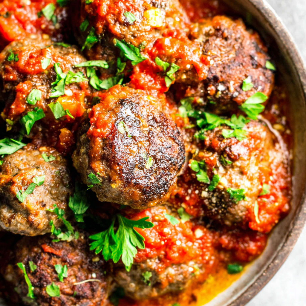 A bowl of meatballs in a red sauce.