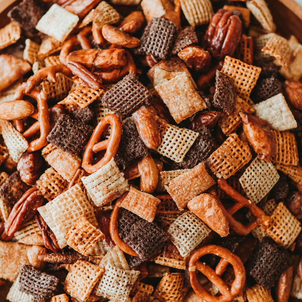 A bowl of cereal with nuts and pretzels.