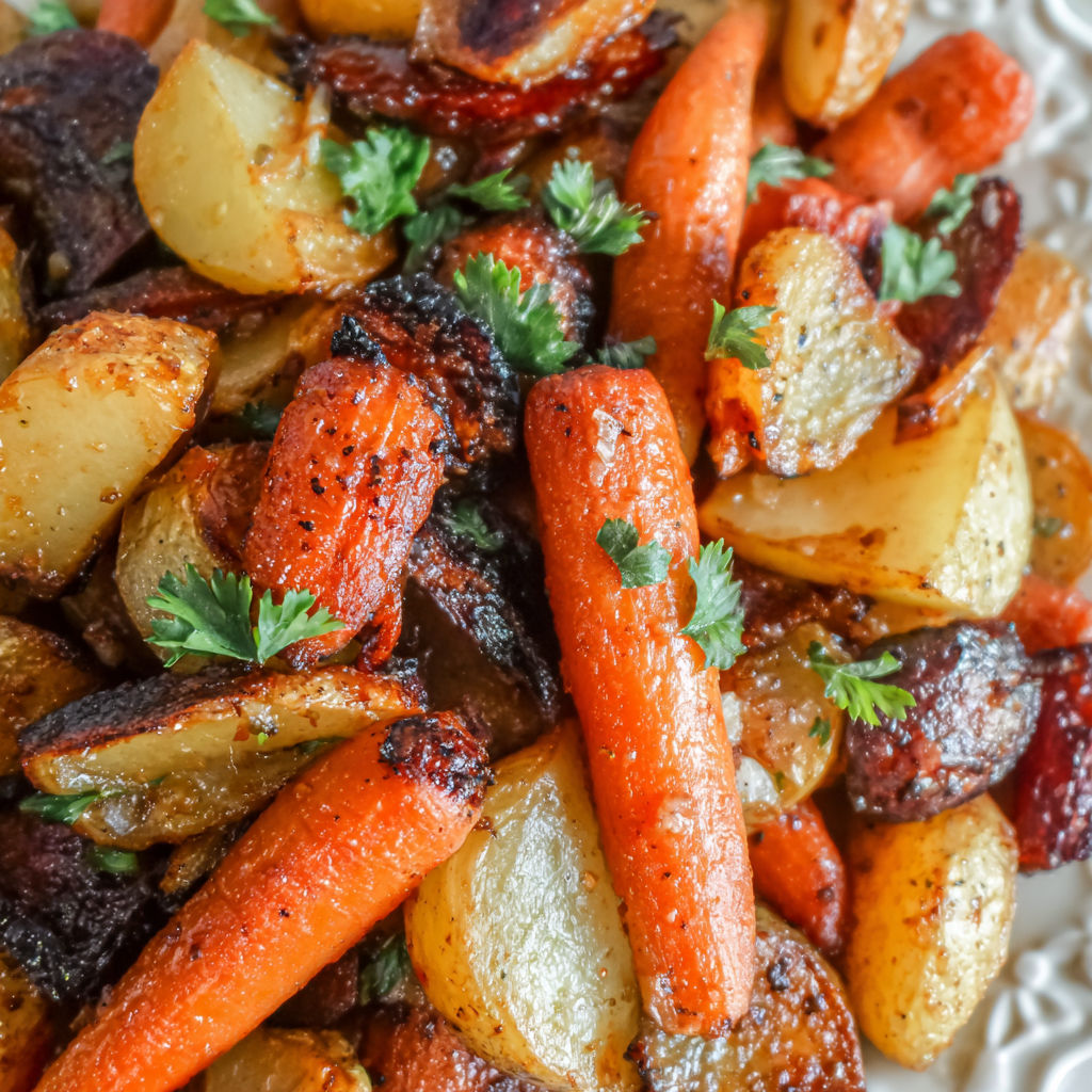 A dish of cooked vegetables, including carrots and potatoes.
