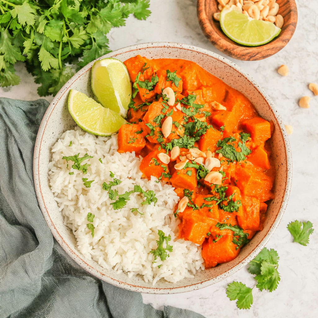 A bowl of rice and meat with a lime wedge on the side.