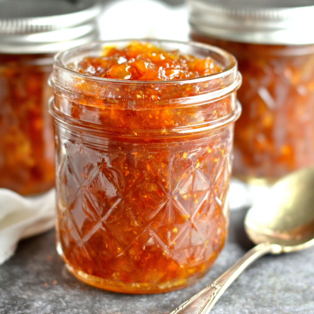 A jar of jam with a spoon in it.