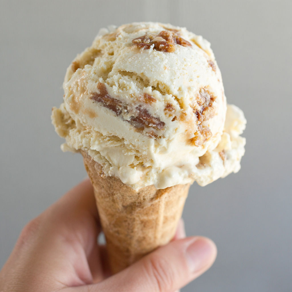 A person is holding a scoop of ice cream.