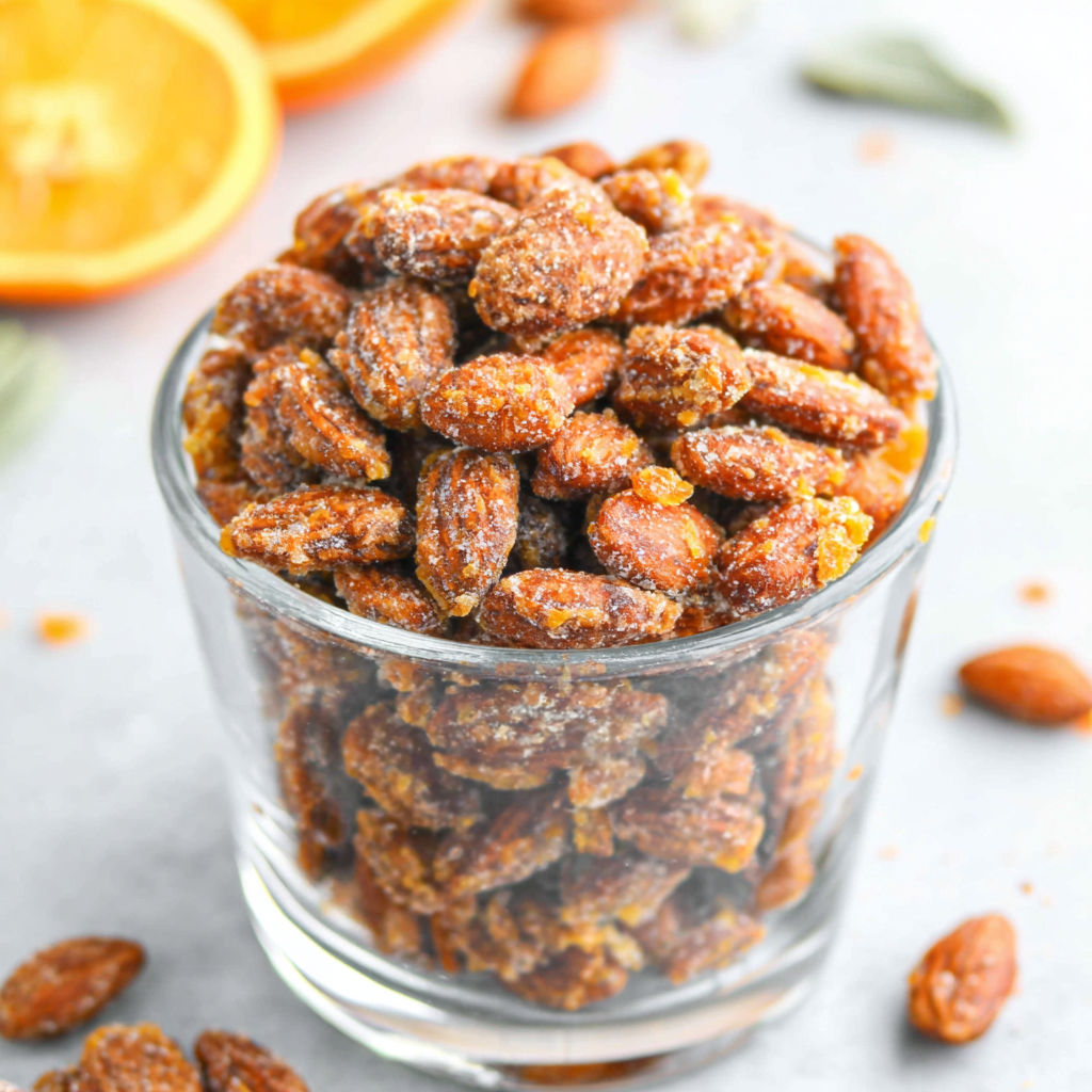 A glass container filled with almonds.