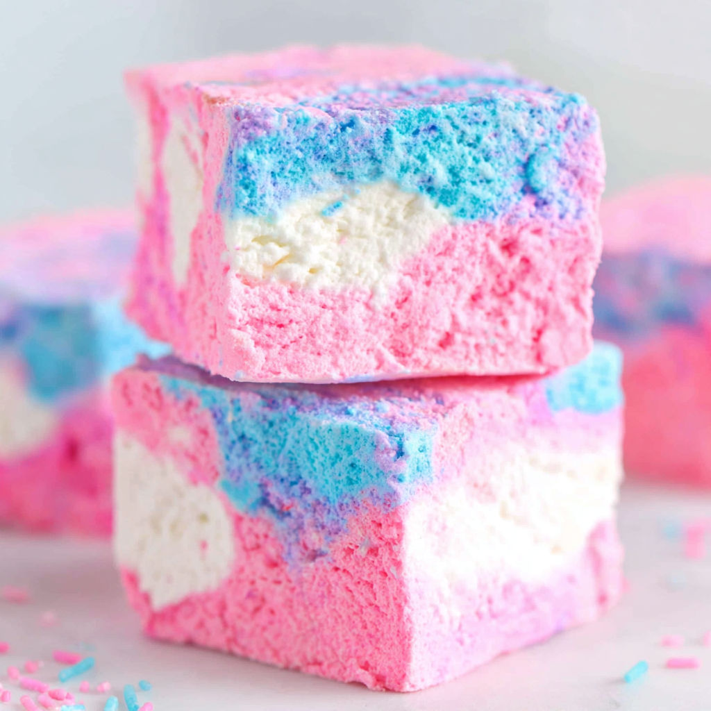 A close up of a piece of cake with pink and blue frosting.