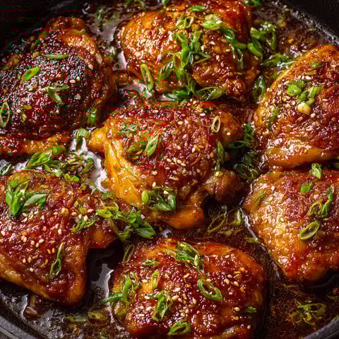A pan of chicken with green onions.
