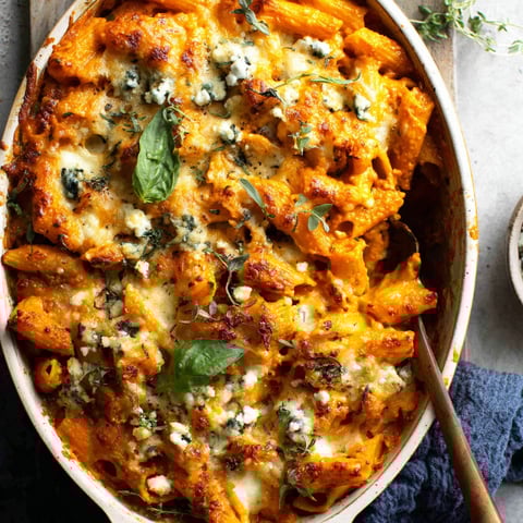 A bowl of pasta with cheese and herbs.