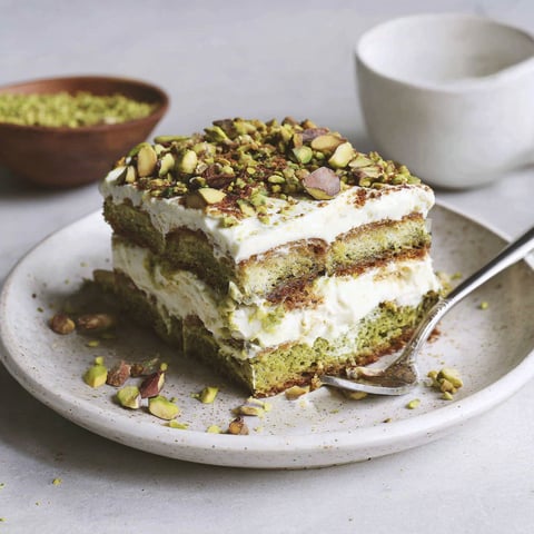A slice of cake with almonds on top.