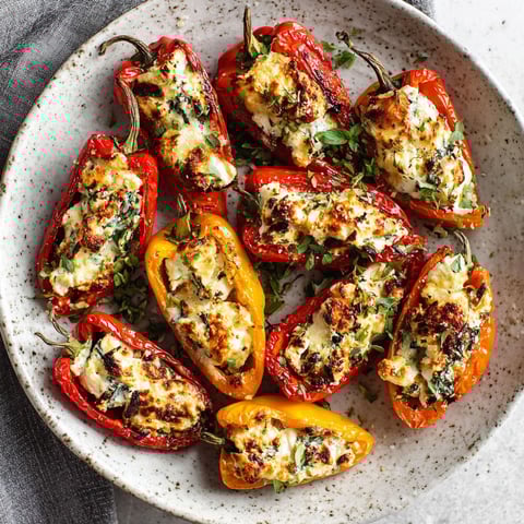 A plate of peppers with cheese on top.