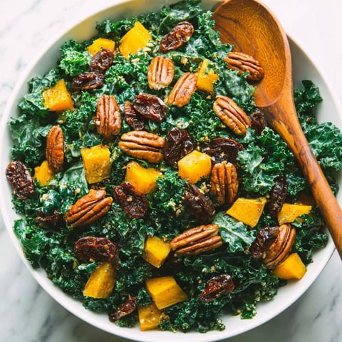 A bowl of salad with a wooden spoon.