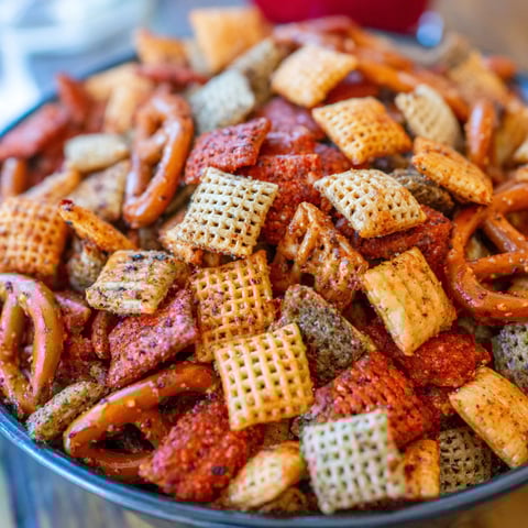 A bowl of chips and pretzels.