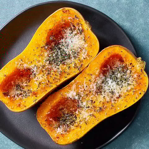 Two slices of roasted butternut squash with cheese and herbs.