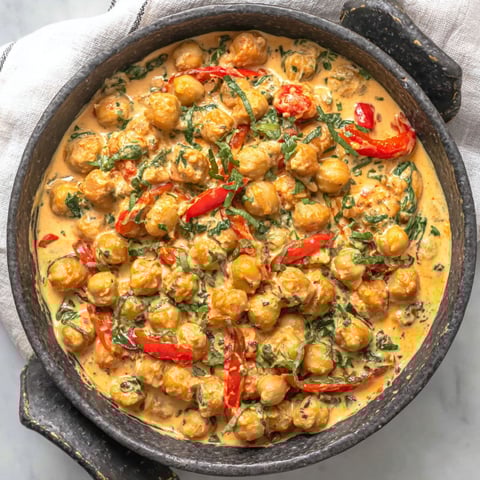 A bowl of chickpeas with a spicy sauce.