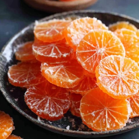 A bowl of oranges with a recipe on the side.