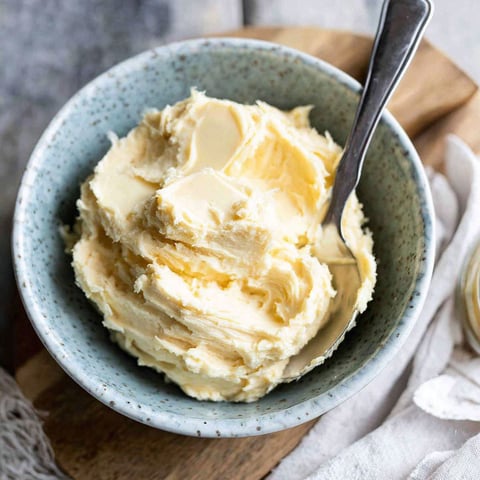 A bowl of butter on a table.