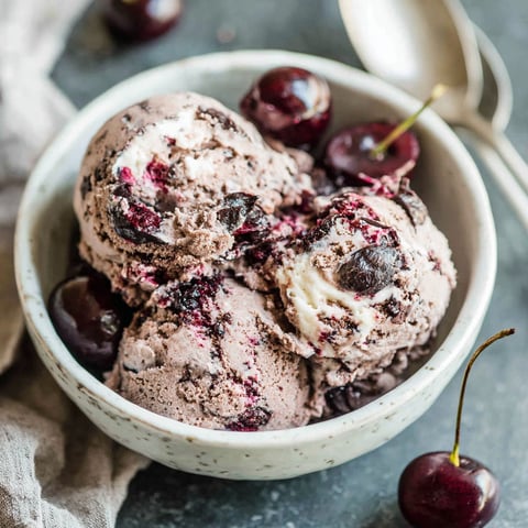 A bowl of cherries and ice cream.
