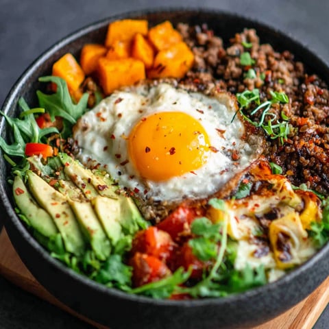 A bowl of food with a fried egg on top.